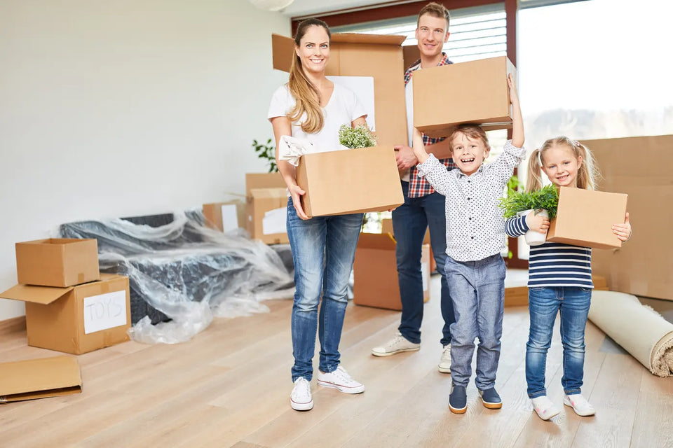 Familie zieht mit Umzugskartons in eine neue Wohnung ein
